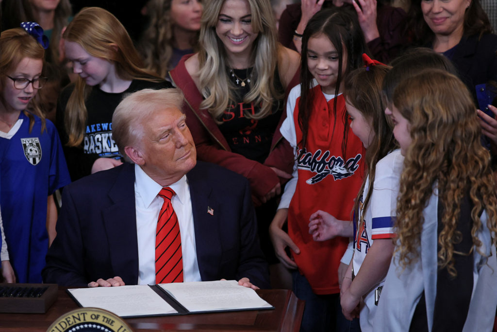 U.S. President Donald Trump sits to sign an executive order banning transgender girls and women from participating in women's sports, in the East Room at the White House in Washington, U.S., February 5, 2025. REUTERS/Leah Millis